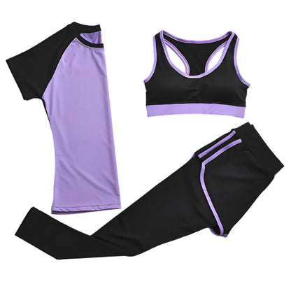 A set of yoga clothes consisting of a sports bra, a t-shirt, and leggings. The sports bra has purple strap and a black center, the t-shirt is primarily purple with black sleeves, and the leggings are black with purple accents.