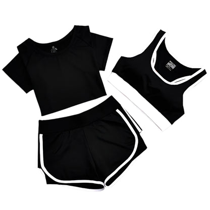 A set of yoga clothes consisting of a sports bra, a t-shirt, and a short pant. The sports bra has white straps and a black center, the t-shirt is primarily black with white straps short sleeves, and the leggings are black with white accents.