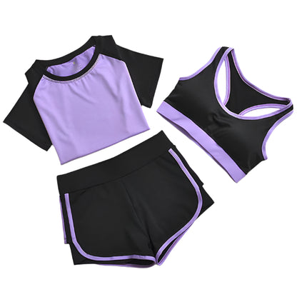 A set of yoga clothes consisting of a sports bra, a t-shirt, and leggings. The sports bra has black straps and a purple center, the t-shirt is primarily purple with black sleeves, and the leggings are black with purple accents.